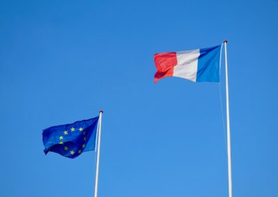 two flags flying next to each other in a blue sky